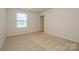 Bright bedroom features neutral carpeting, white walls, and a window for natural light at 4242 Plumeria Way, Fort Mill, SC 29707