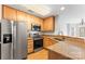 Well-lit kitchen with stainless steel appliances, granite countertops, and wood cabinets at 6464 Park Pond Dr # 7, Charlotte, NC 28262