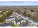 Drone shot shows neighborhood with rows of townhouses among landscaped yards and a forested backdrop at 6464 Park Pond Dr # 7, Charlotte, NC 28262