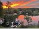 Beautiful sunset over the lake with a boat dock, homes across the lake, and green trees at 649 46Th Avenue Ne Dr, Hickory, NC 28601