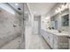 Luxurious bathroom with a walk-in shower featuring marble tiling, dual vanities, and ample counter space at 6858 Hunts Mesa Dr, Fort Mill, SC 29707