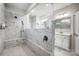 Bright bathroom featuring a spacious, marble tiled walk-in shower with a glass enclosure and a modern vanity at 6858 Hunts Mesa Dr, Fort Mill, SC 29707