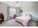 This bedroom features a bed with pink covers, a desk by the window, and neutral colored walls at 6858 Hunts Mesa Dr, Fort Mill, SC 29707