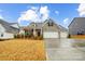 Charming home with a stone facade, three-car garage, and manicured landscaping at 6858 Hunts Mesa Dr, Fort Mill, SC 29707