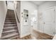 Hallway leading to the kitchen, featuring wood floors and a staircase at 6858 Hunts Mesa Dr, Fort Mill, SC 29707