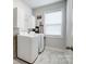 Bright laundry room equipped with modern washer and dryer and plenty of storage at 6858 Hunts Mesa Dr, Fort Mill, SC 29707