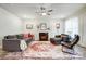 Cozy living room with a fireplace, fan, light wood floors, and a stylish rug at 6858 Hunts Mesa Dr, Fort Mill, SC 29707