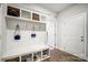 Inviting mudroom featuring built-in bench with storage, coat hooks, and wood-look floors at 6858 Hunts Mesa Dr, Fort Mill, SC 29707