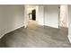 Light-filled bedroom features sleek floors, neutral walls, and open doorway to kitchen and bathroom at 8069 Cedar Glen Dr, Charlotte, NC 28212