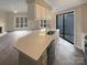 Modern kitchen island featuring sink, dishwasher, and seating space with easy access to balcony at 8069 Cedar Glen Dr, Charlotte, NC 28212