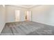 Bright bedroom with gray carpeting, neutral walls, and multiple doorways leading to other rooms at 8716 Acadia Pkwy # 596, Sherrills Ford, NC 28673