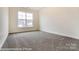 Bright bedroom showcasing neutral paint, carpet floors and large window illuminating the space at 8716 Acadia Pkwy # 596, Sherrills Ford, NC 28673
