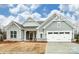 Traditional home with a two-car garage, gray siding and stone accents with manicured lawn at 8716 Acadia Pkwy # 596, Sherrills Ford, NC 28673