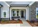Covered front porch with stone accents, gray siding, a front storm door and manicured landscaping at 8716 Acadia Pkwy # 596, Sherrills Ford, NC 28673