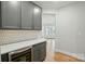 Kitchen with gray cabinetry and quartz countertops with wine cooler and stylish backsplash at 8716 Acadia Pkwy # 596, Sherrills Ford, NC 28673