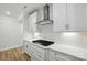Modern white kitchen features a gas cooktop, stainless steel range hood, and stylish backsplash at 8716 Acadia Pkwy # 596, Sherrills Ford, NC 28673