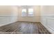 Empty room with decorative chair rail molding, hardwood floors, and natural light from large windows at 8716 Acadia Pkwy # 596, Sherrills Ford, NC 28673