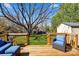 Deck with a blue cushioned outdoor lounge area, overlooking a spacious yard, and a storage shed at 9108 Clifton Meadow Dr, Matthews, NC 28105