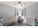 Cozy Bedroom features a crib, changing table, rocker, and two windows providing natural light at 9108 Clifton Meadow Dr, Matthews, NC 28105