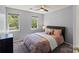 Bright bedroom with two windows, carpet floors, and a comfortable bed with soft lighting at 9108 Clifton Meadow Dr, Matthews, NC 28105