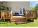 View of the outdoor wooden deck with seating and stairs leading to the yard at 9108 Clifton Meadow Dr, Matthews, NC 28105