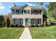Charming two-story home featuring a well-manicured lawn, symmetrical windows, and a welcoming blue front door at 9108 Clifton Meadow Dr, Matthews, NC 28105
