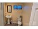 Compact bathroom with pedestal sink and toilet; features neutral colors at 1024 Old Mountain View Rd, Mount Holly, NC 28120