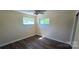 An inviting bedroom with wood-look floors, a ceiling fan, and two windows offering natural light at 1024 Old Mountain View Rd, Mount Holly, NC 28120