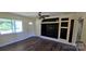 Bright living room with modern ceiling fan, an open door, and a sleek, built-in feature wall at 1024 Old Mountain View Rd, Mount Holly, NC 28120