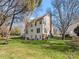 Large backyard with grassy lawn, mature trees, and side view of the house at 10700 Summitt Tree Ct, Charlotte, NC 28277