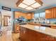 Open kitchen area with wood cabinets, granite countertops, stainless steel appliances, and wooden floors at 10700 Summitt Tree Ct, Charlotte, NC 28277