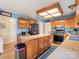 Well-lit kitchen with an island, stainless steel appliances, and wood cabinets and flooring at 10700 Summitt Tree Ct, Charlotte, NC 28277