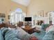 Bright living room features vaulted ceilings, large windows, a fireplace, and comfortable seating at 10700 Summitt Tree Ct, Charlotte, NC 28277