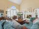 Bright living room features vaulted ceilings, large windows, a fireplace, and comfortable seating at 10700 Summitt Tree Ct, Charlotte, NC 28277