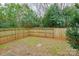 Enclosed backyard with a wood fence surrounded by mature trees and lawn at 1461 Flintwood Dr, Rock Hill, SC 29732