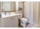 Compact bathroom featuring a vanity with sink, toilet, and shower with a decorative gold curtain at 1469 Flintwood Dr, Rock Hill, SC 29732