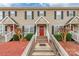 Inviting townhome featuring neutral siding, black shutters, a red front door, and attractive landscaping at 1469 Flintwood Dr, Rock Hill, SC 29732