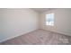 Bright bedroom features neutral walls, carpet, and a window offering natural light at 1760 Braemar Village Dr, Monroe, NC 28110