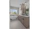 Modern bathroom featuring a soaking tub, large window, double sinks, and sleek vanity at 1828 Haines St, Charlotte, NC 28216