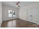 Well-lit bedroom featuring hardwood floors, a ceiling fan, and multiple windows at 1828 Haines St, Charlotte, NC 28216