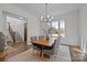 Elegant dining area with wainscoting, natural light, and a stylish chandelier adjacent to the living area at 1828 Haines St, Charlotte, NC 28216