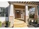 Inviting front porch with wooden ceiling, classic columns, and brick accents, offering a cozy entrance at 1828 Haines St, Charlotte, NC 28216