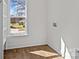 Bright laundry room with wood floors, a window, and white walls at 1828 Haines St, Charlotte, NC 28216