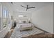 Bright main bedroom featuring hardwood floors, ceiling fan, a window view, and decor at 1828 Haines St, Charlotte, NC 28216
