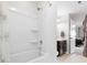 Bright bathroom features a bathtub with shower, dark cabinets, and neutral tile flooring at 1874 Larkspur Way, Tega Cay, SC 29708