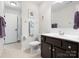Clean bathroom with dark cabinets, neutral tile flooring, and shower with curtain at 1874 Larkspur Way, Tega Cay, SC 29708