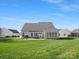 Exterior backyard view showcasing a well-maintained lawn, patio, and sunroom at 2020 Holly Villa Cir, Indian Trail, NC 28079