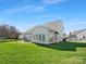 View of the backyard features an expansive lawn, patio, and sunroom, creating an inviting outdoor space at 2020 Holly Villa Cir, Indian Trail, NC 28079