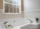 A bright bathroom featuring a soaking tub, large window, and a tray with rolled towels and soaps for comfort at 2020 Holly Villa Cir, Indian Trail, NC 28079