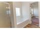 A large tub and glass block window are features of this bright and spacious bathroom at 212 Mary Caroline Springs Dr, Mount Holly, NC 28120